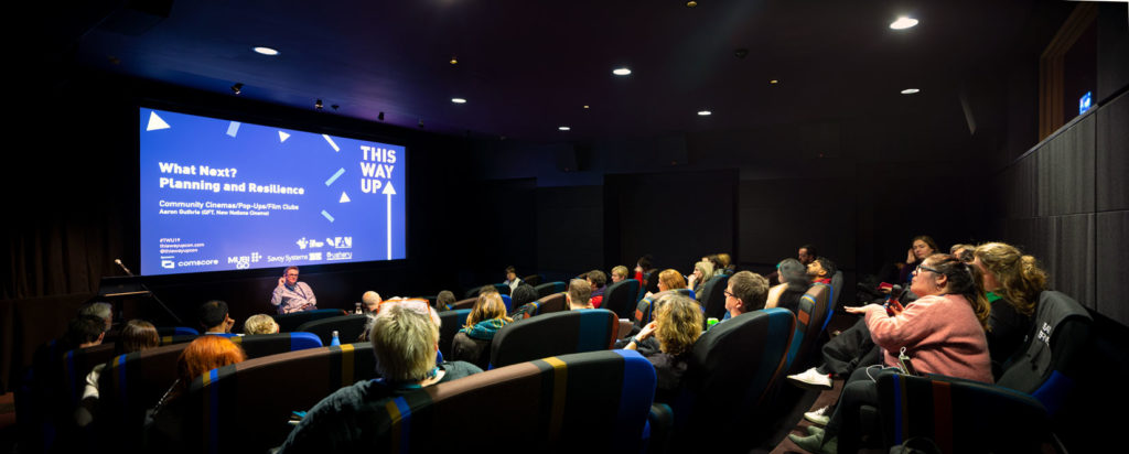 small cinema auditorium, speaker and audience member in conversation 