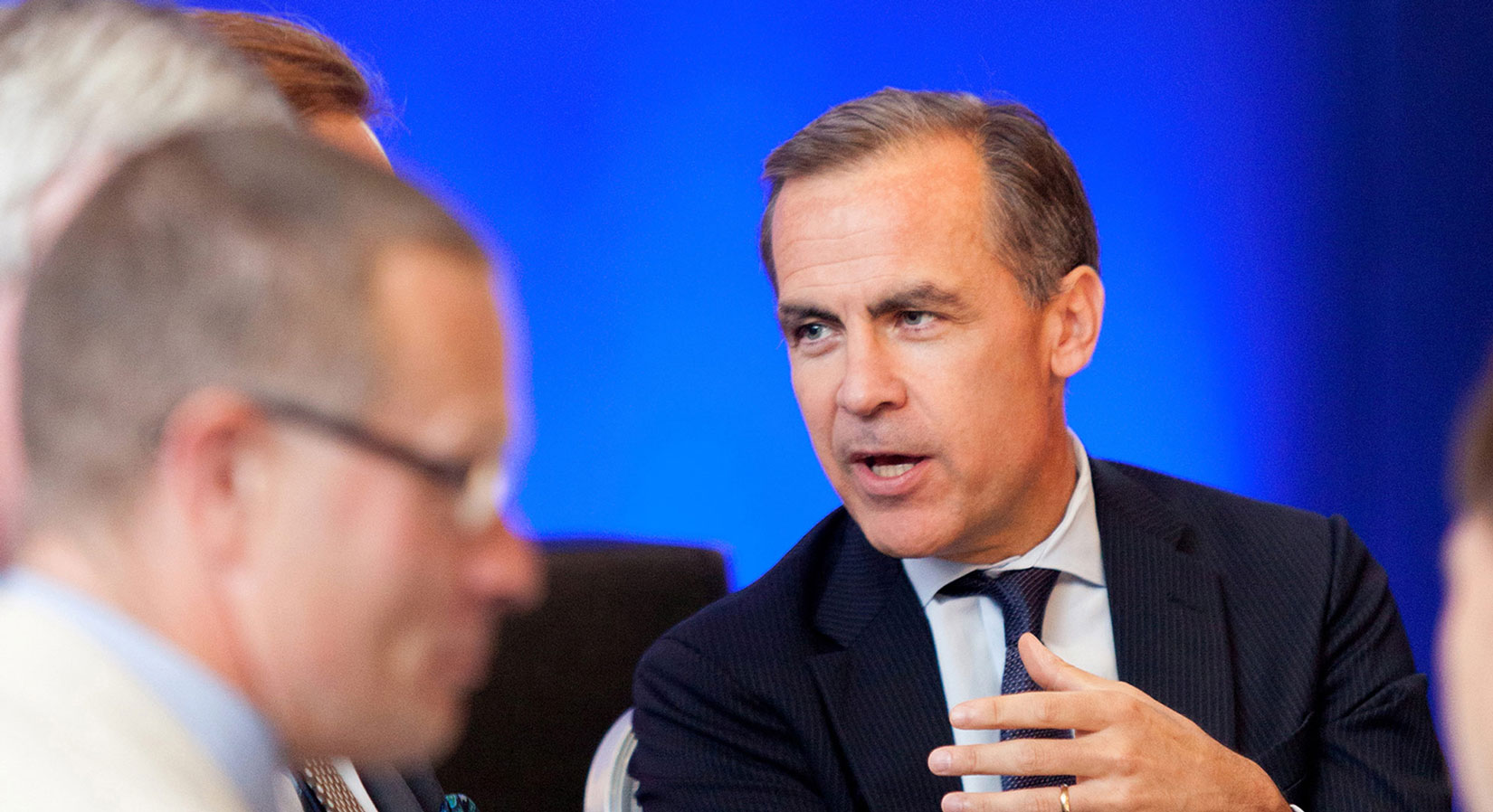 Event photography shot of Mark Carney engaged in conversation Nottingham Chamber event deep blue background
