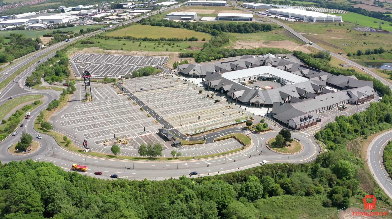 Aerial drone shot showing carparks and buildings of McArthurGlen designer Outlet