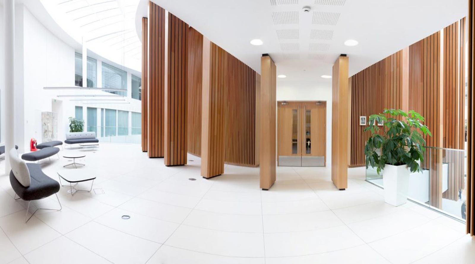 Interior of Derby City Council office looking from inside to entrance which surrounded by floor to ceiling wooden slatted pillars by interior photographer Matthew Jones